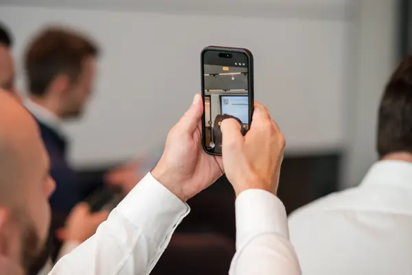 An attendee photographs the panel on a phone at Goodwin — Management Incentives in the AI Era