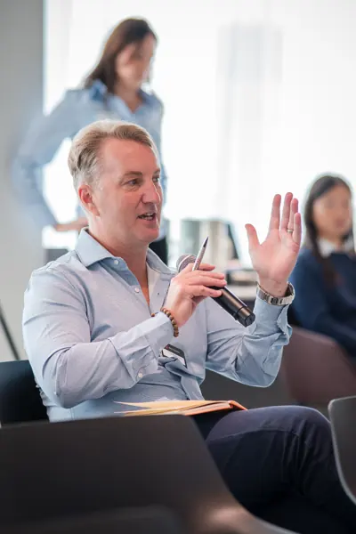 An attendee asking a question with a microphone at Goodwin — Management Incentives in the AI Era