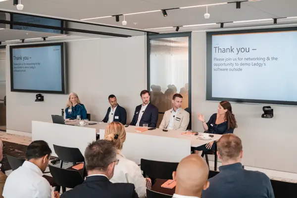 The speakers and audience viewed across the conference room at Goodwin — Management Incentives in the AI Era