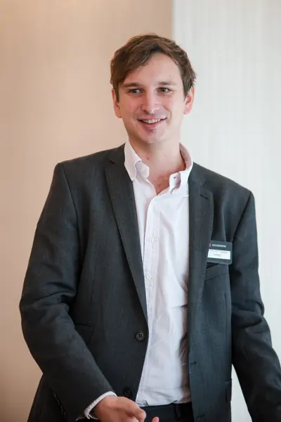 A smiling guest in the networking space at Goodwin — Management Incentives in the AI Era