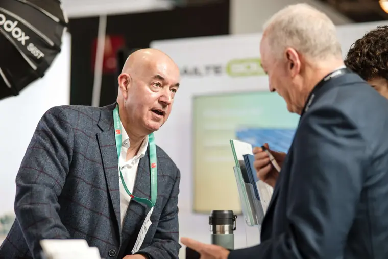 An exhibitor explaining a point to a visitor at Fáilte Solar at Solar & Storage