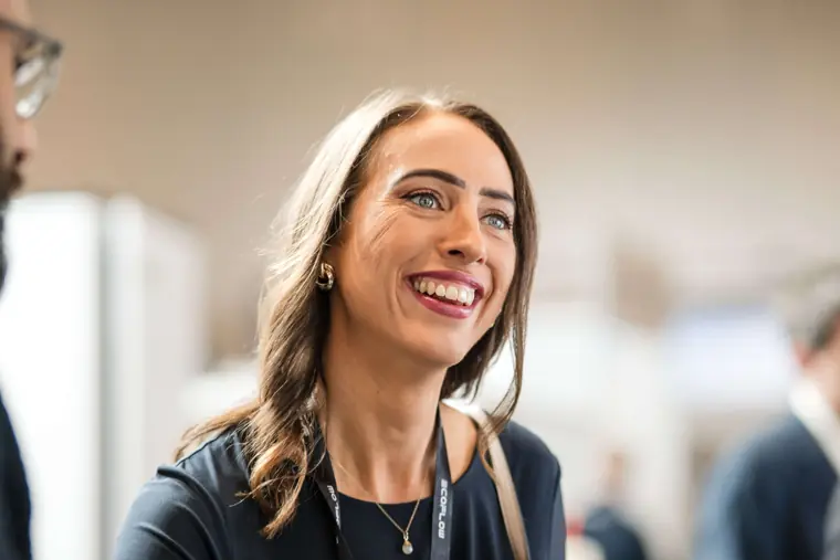 A guest smiling during a stand conversation at Fáilte Solar at Solar & Storage