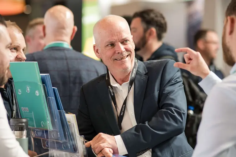 A guest laughing during a conversation at the stand at Fáilte Solar at Solar & Storage