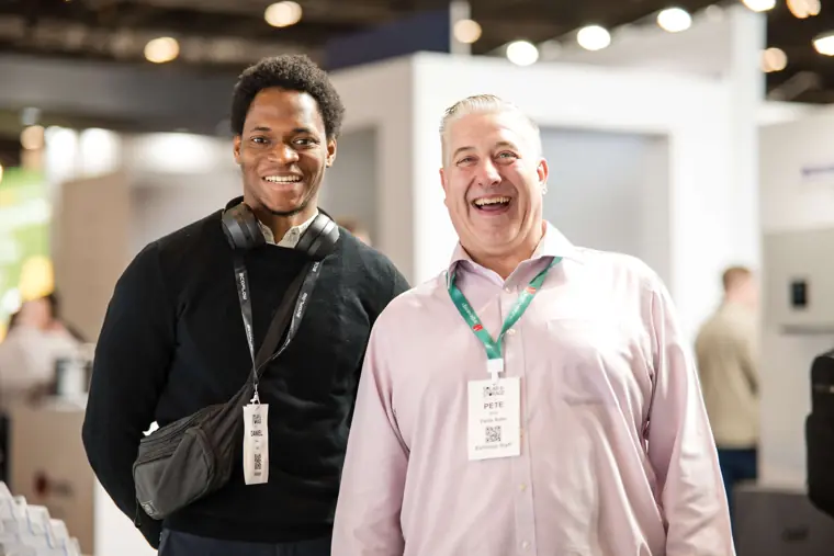 Two attendees laughing together at the exhibition at Fáilte Solar at Solar & Storage