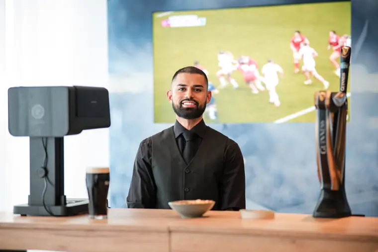 A bartender behind the drinks counter at Goodwin Tavern.