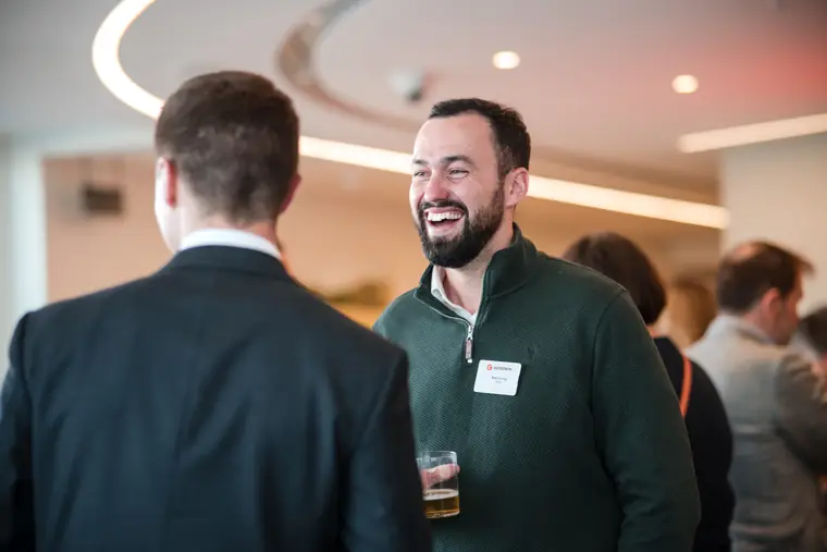 A guest laughing during a group conversation at Goodwin Tavern.