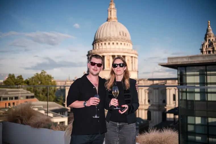 Two guests together against the London skyline at Goodwin Tavern.
