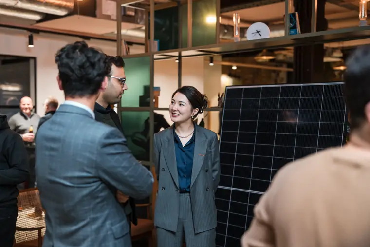 Conversation beside a solar panel exhibit.