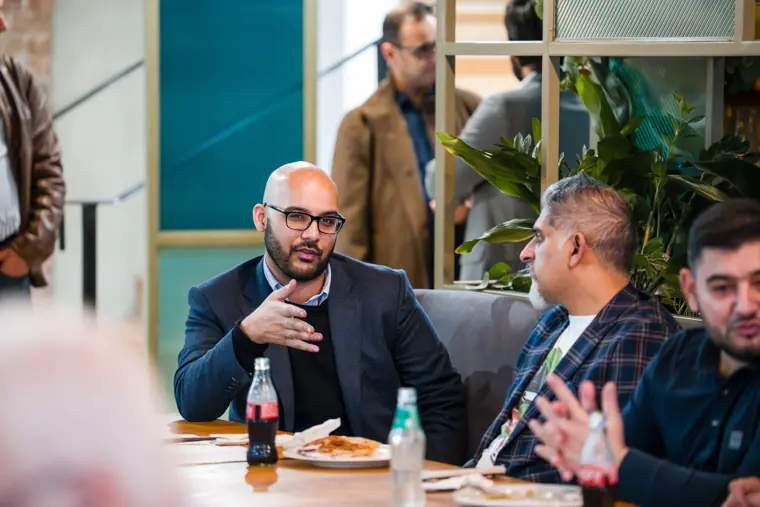 Guests talking at a table over dinner.