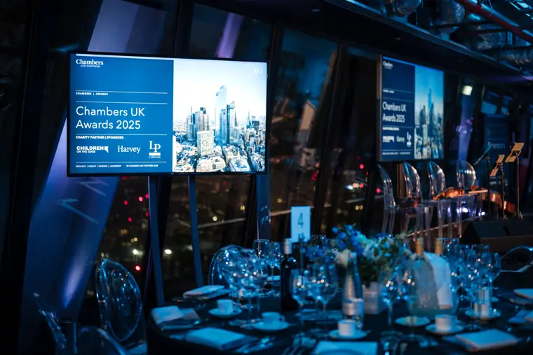 Chambers UK Awards signs across the blue-lit venue.