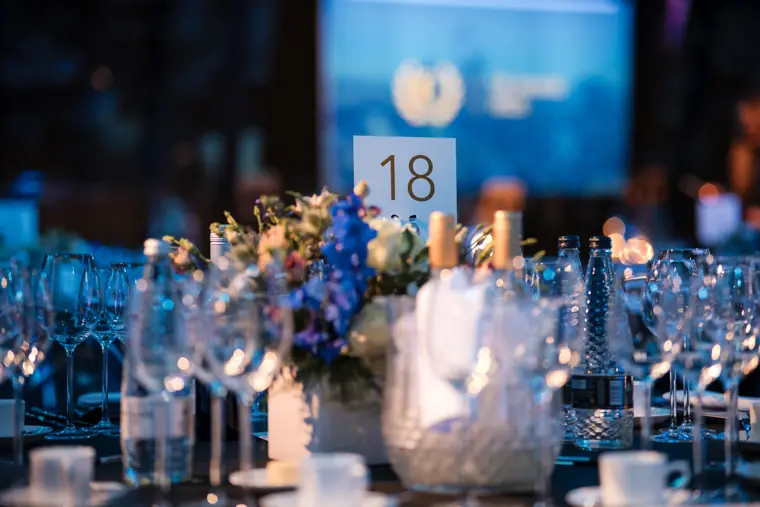 A flower arrangement and table number at the awards dinner.