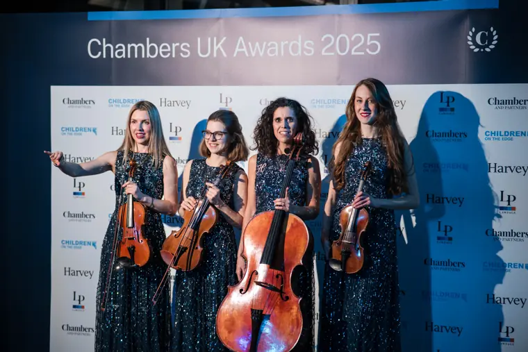 The string quartet posing beside the awards backdrop.