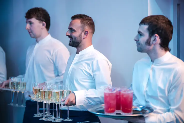 Servers carrying drinks through the reception.
