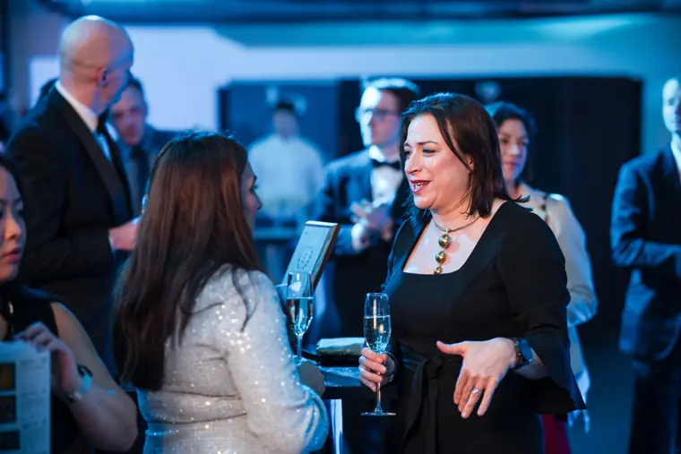 Guests greeting one another beside the bar.