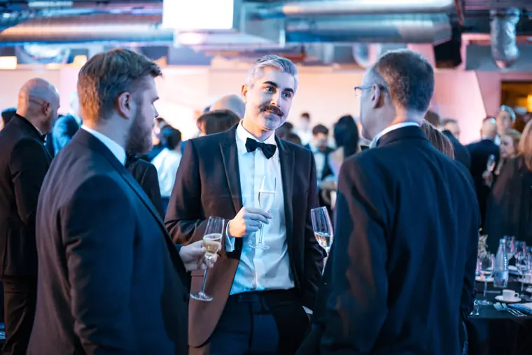 Guests talking beside the dinner tables.