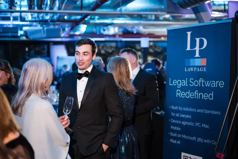 Guests talking by a sponsor display.