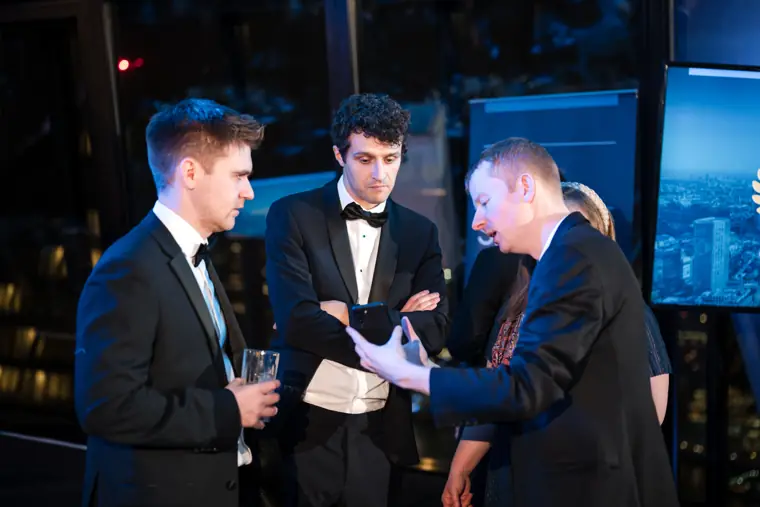 A presenter and guests reviewing the awards programme.