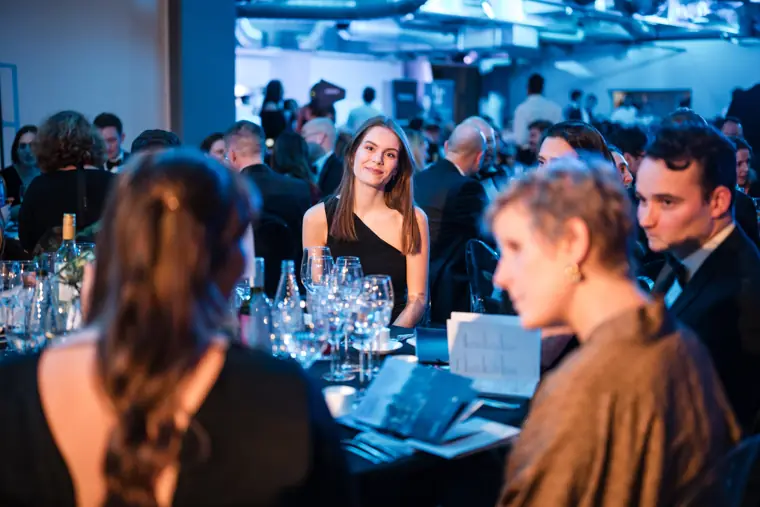 Guests following the ceremony from their table.