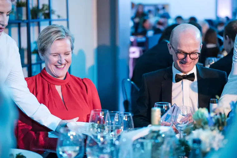 Two dinner guests smiling at the awards.
