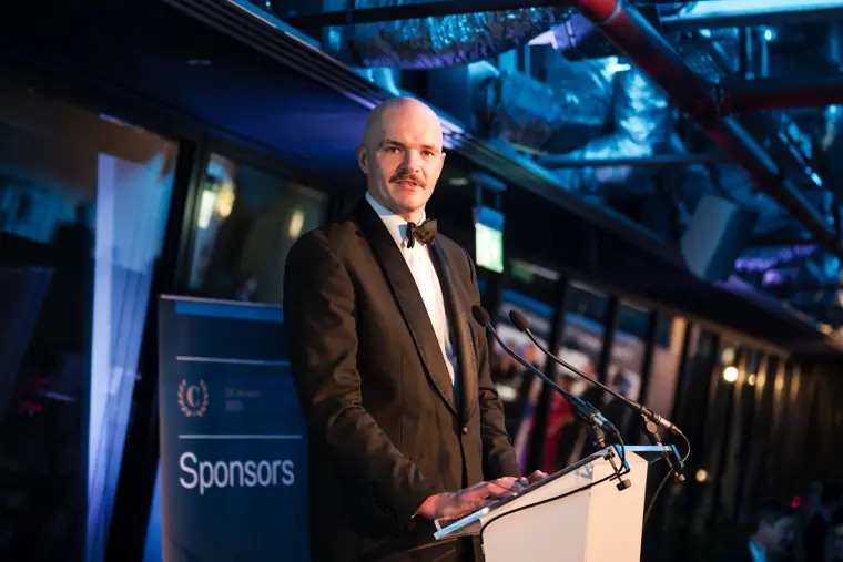 A presenter speaking at the awards lectern.