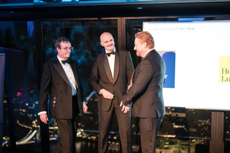 An award winner greeting the presenter on stage.