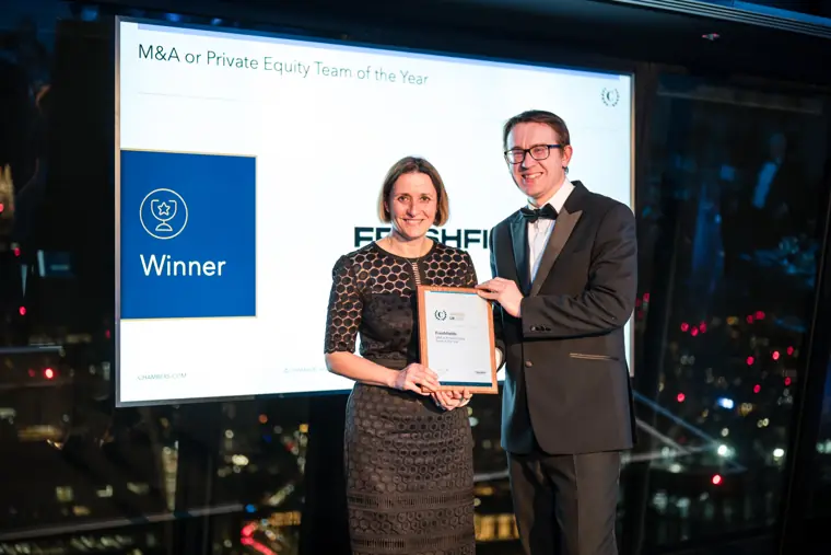 A winner holding a certificate on stage.