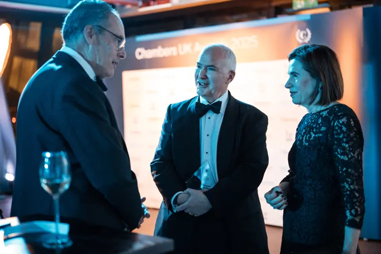 Guests talking beneath the awards signage.