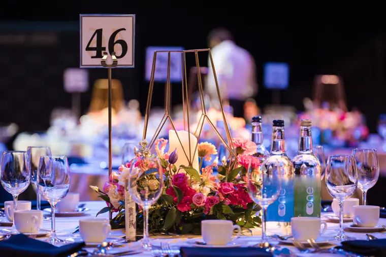 Flowers and table settings prepared for the awards dinner.