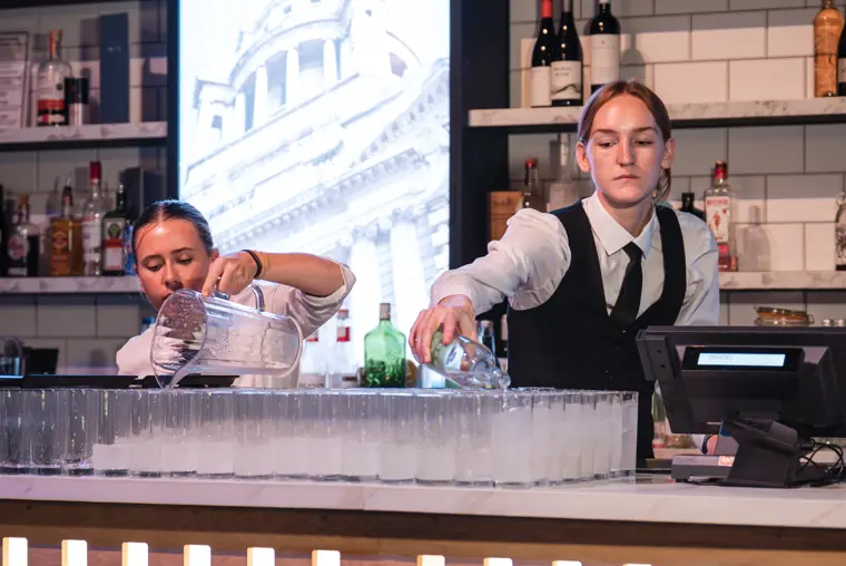 Bar staff preparing drinks for arriving guests.