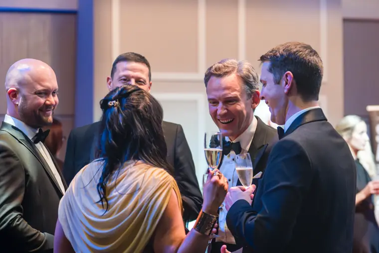 Colleagues greeting one another over drinks.