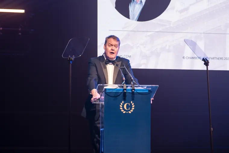 A speaker addressing the awards from the Chambers lectern.