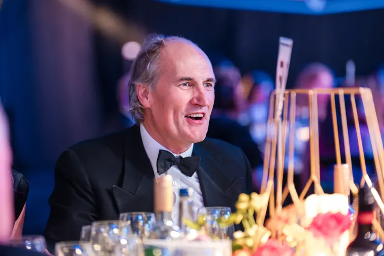 A dinner guest smiling across the table.