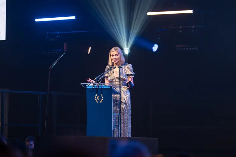 A presenter speaking under the stage lights.