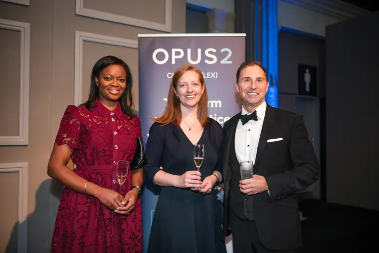 Three guests posing beside the partner display.
