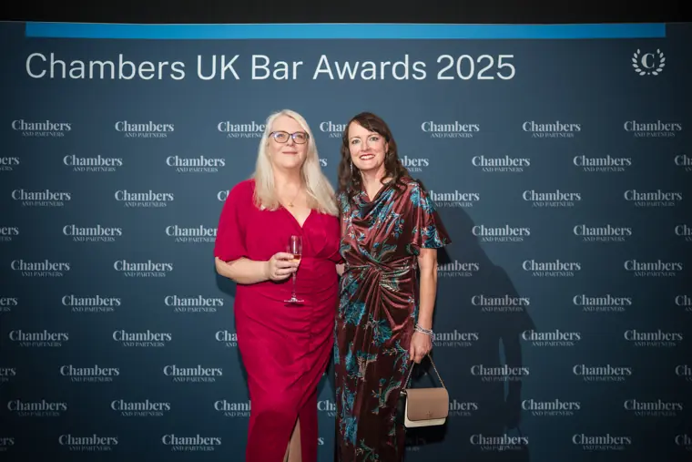 Two guests posing with the Chambers backdrop.