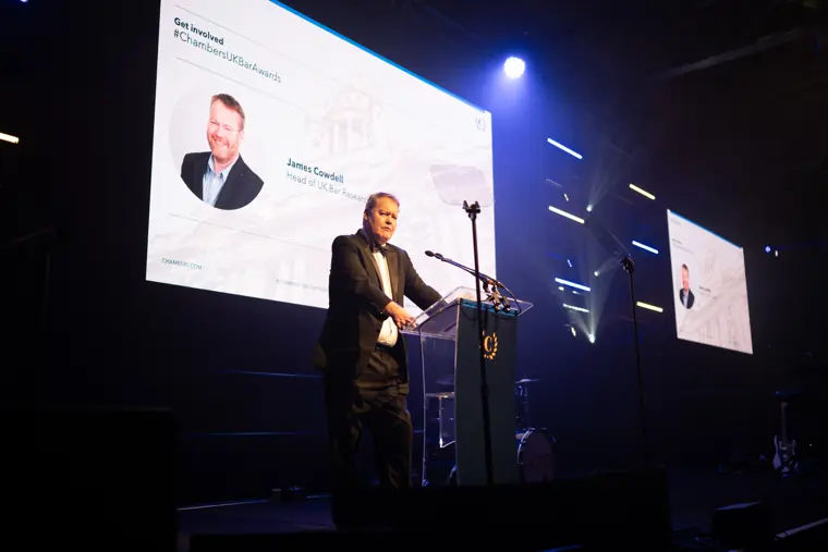 A speaker introducing the next award on stage.