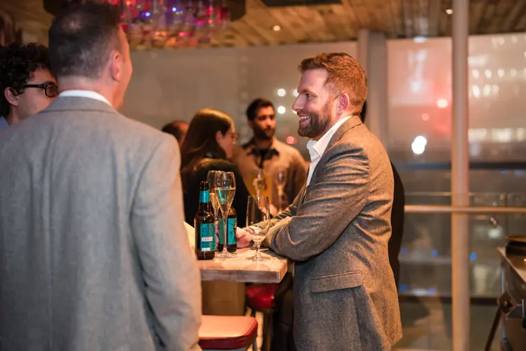 Guests greeting one another at the ClickUp client dinner.