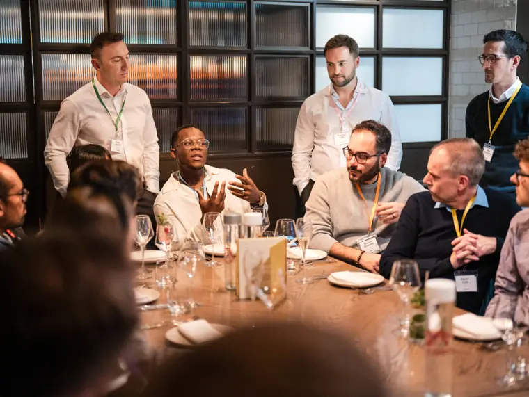 Guests sharing ideas over dinner.