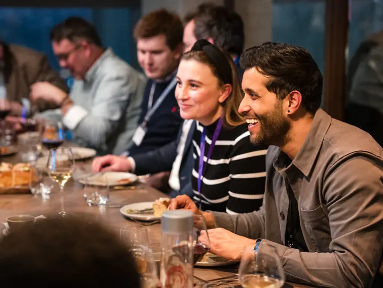 Guests sharing a lighter moment over dinner.