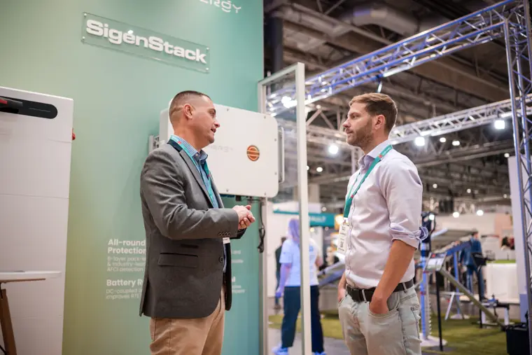 Two people discussing equipment on the stand.