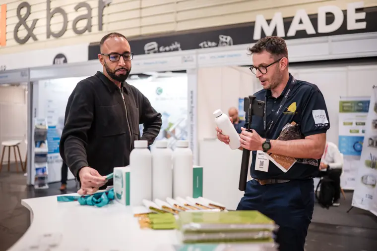 Two attendees discussing the exhibition materials.