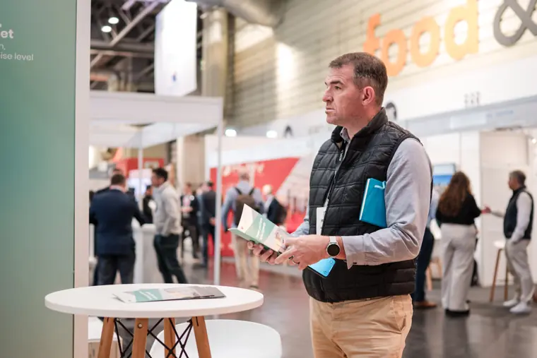 An attendee standing among the trade show displays.