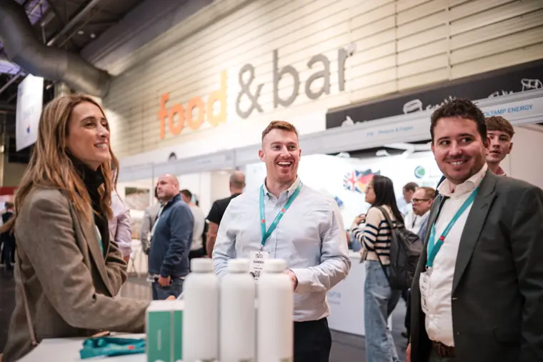 Three attendees sharing a conversation at the stand.