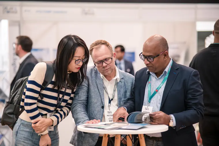 Visitors discussing information in the exhibition hall.