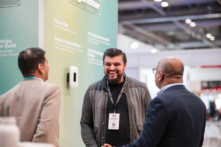Visitors speaking beside the branded wall.