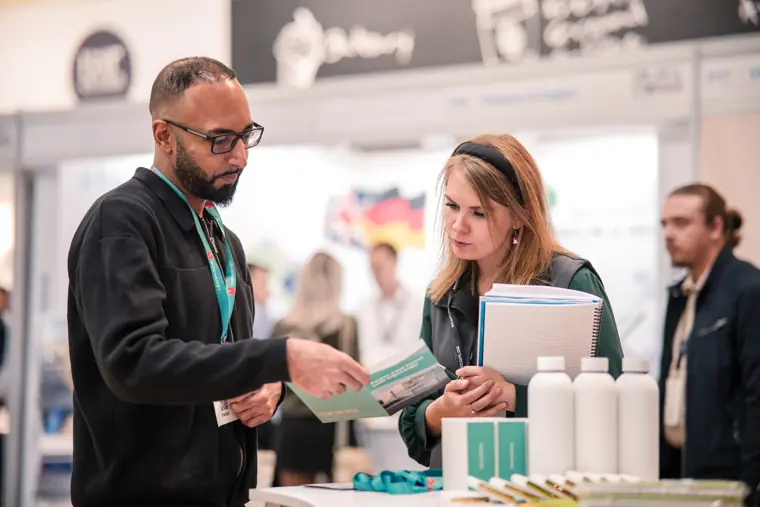 Two attendees reviewing a brochure together.