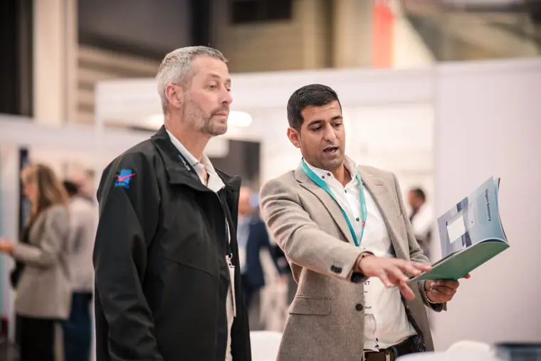 Two attendees photographed beside the stand.