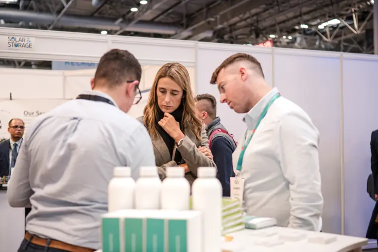 Team members talking with visitors across the stand.