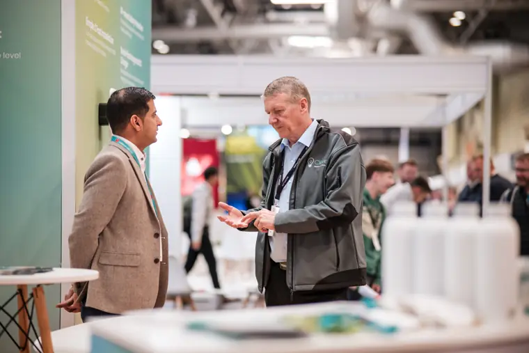 Two people in conversation beside the stand.