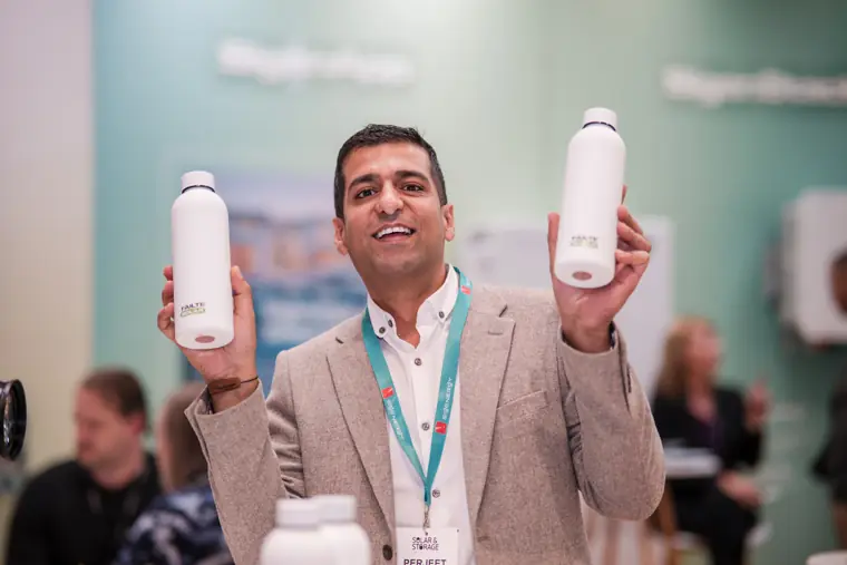 A team member holding products beside the display.